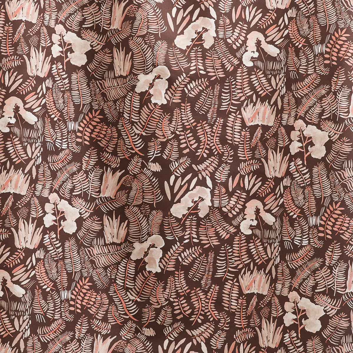 Draped fabric yardage in a painterly botanical print in shades of cream and pink on a brown field.