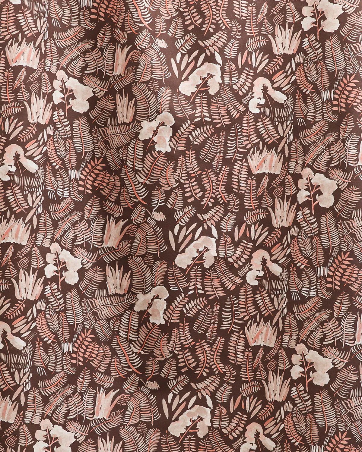 Draped fabric yardage in a painterly botanical print in shades of cream and pink on a brown field.