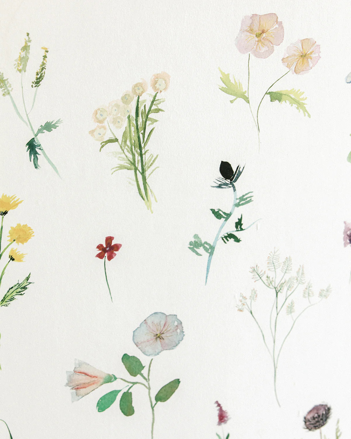 Detail of fabric in a painterly flower print in green and pastels on a cream field.