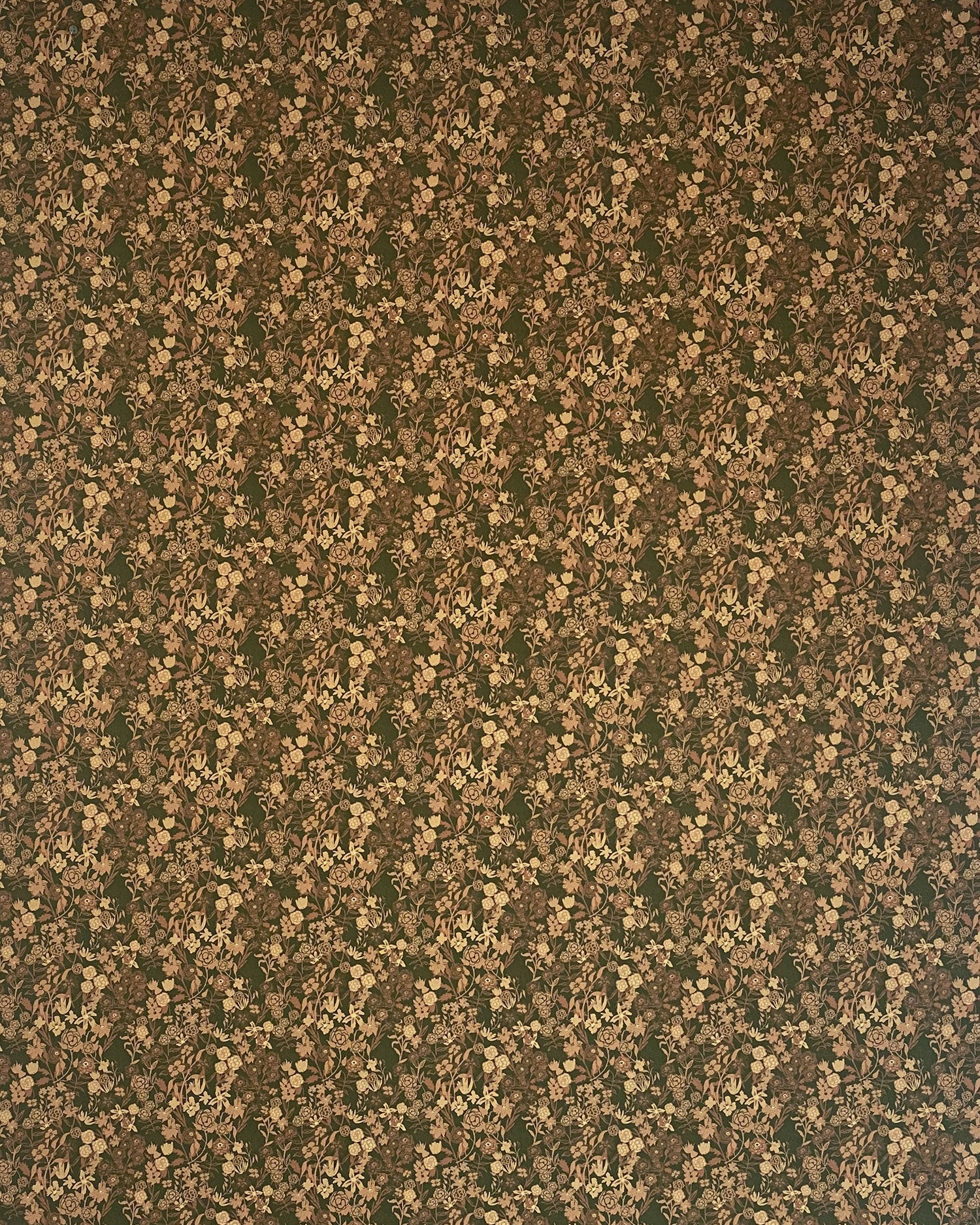 Scaled-out view of wallpaper in a dense small-scale floral print in shades of brown and tan on a green field.