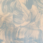 Detail of wallpaper in an abstract paint swatch print in light blue on a tan field.