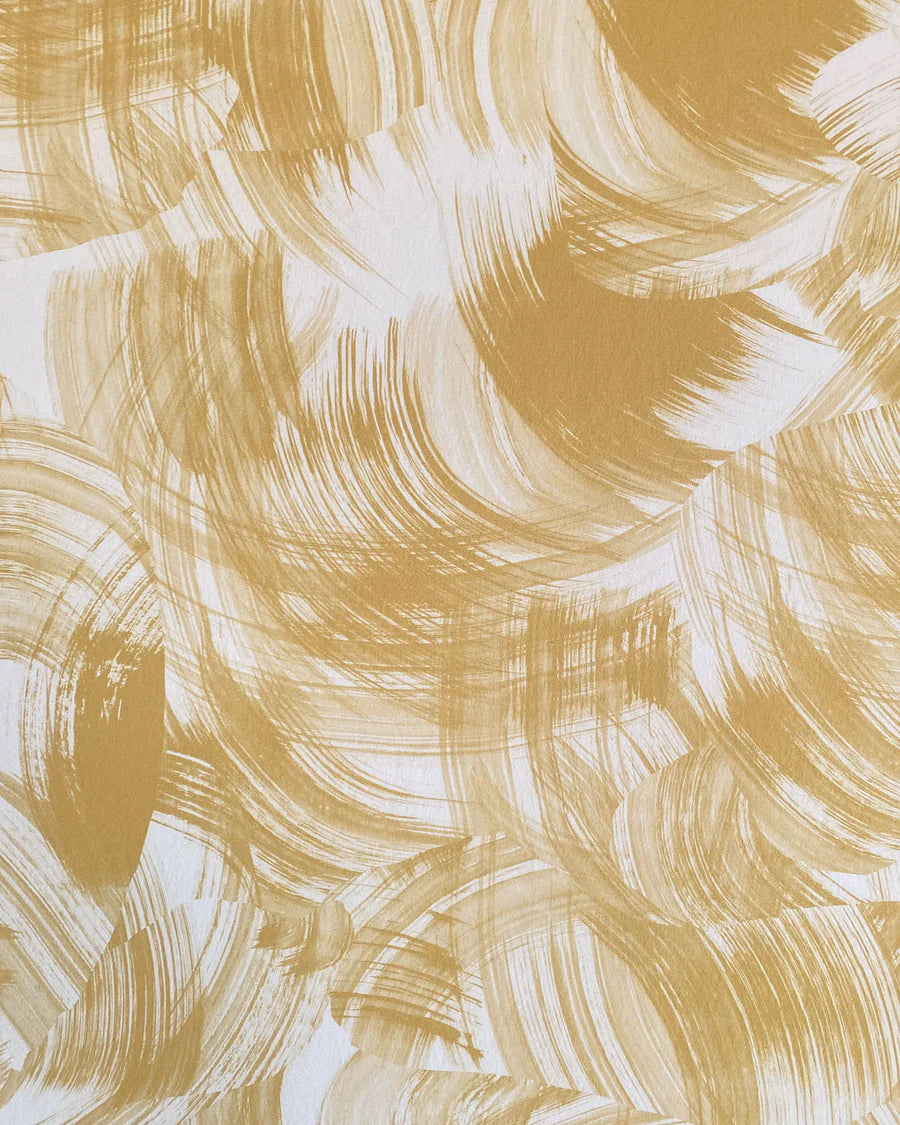 Detail of wallpaper in an abstract paint swatch print in mustard on a cream field.