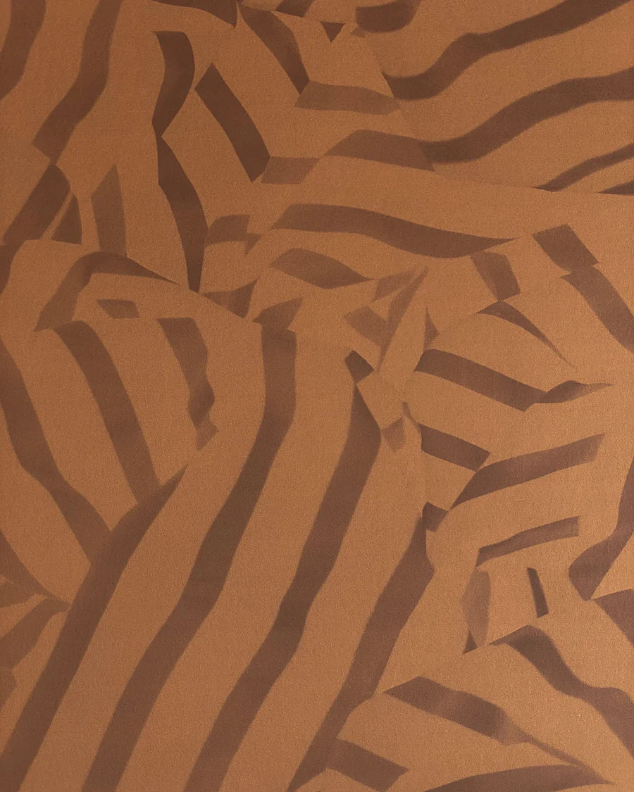 Detail of wallpaper in a playful broken stripe print in dark brown on a brown field.