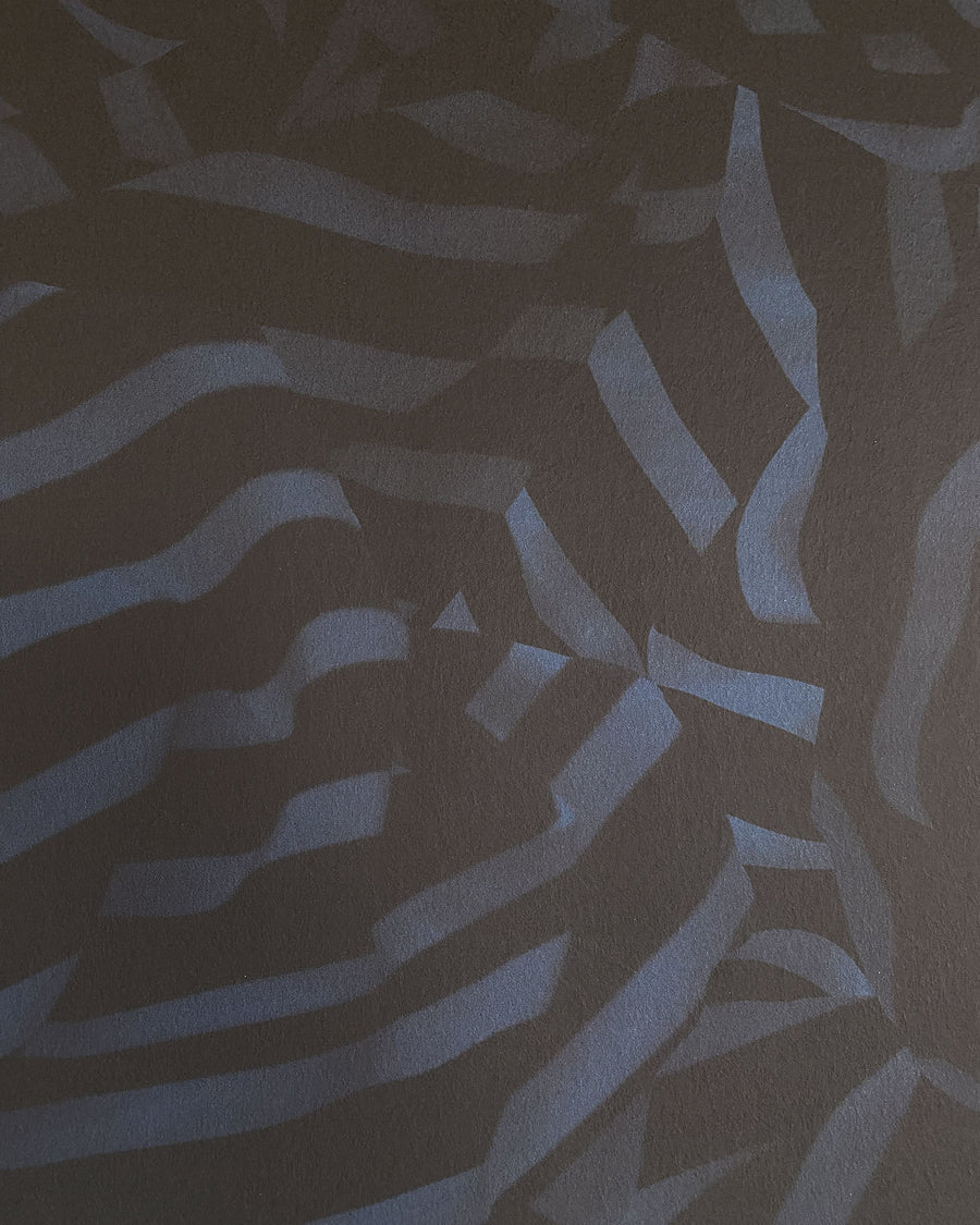 Detail of wallpaper in a playful broken stripe print in black on a navy field.