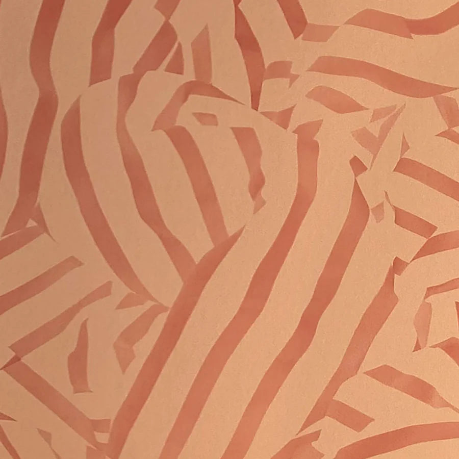 Detail of wallpaper in a playful broken stripe print in rust on an orange field.