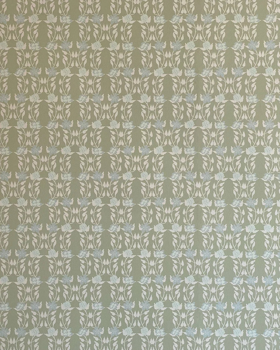 Detail of wallpaper in a linear floral print in blue and white on a green field.