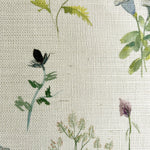 Close-up of fabric in a painterly flower print in green and pastels on a cream field.