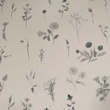 Detail of wallpaper in a painterly flower print in shades of gray on a cream field.