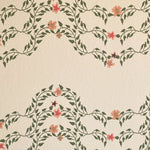 Detail of wallpaper in a curving floral stripe print in shades of orange and green on a cream field.