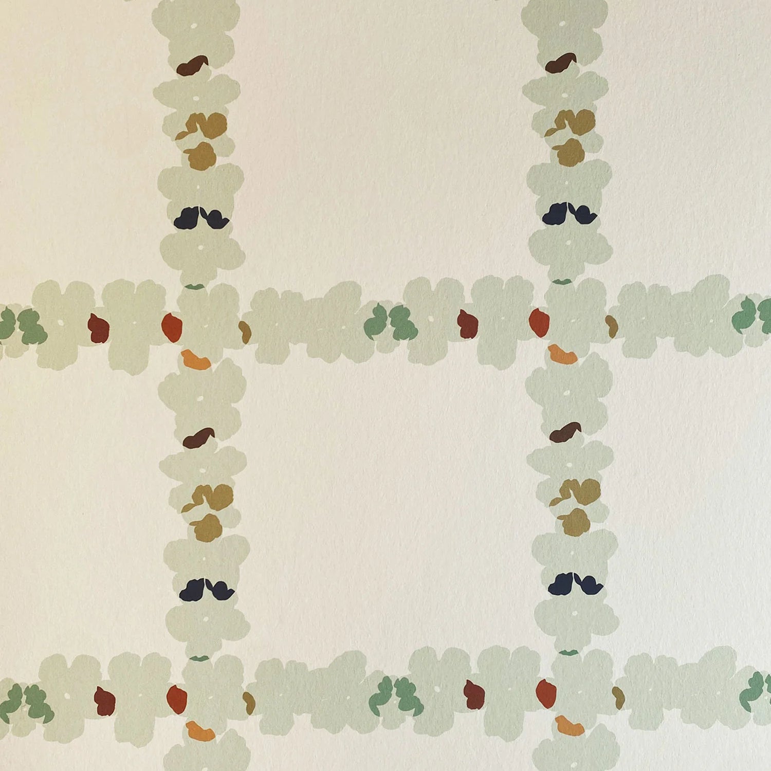 Detail of wallpaper in a floral grid print in cream, green and pink on a white field.