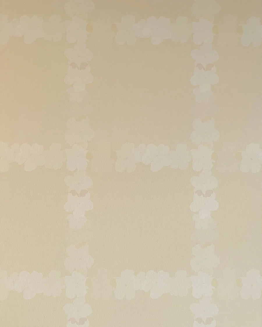 Detail of wallpaper in a floral grid print in cream on a tan field.