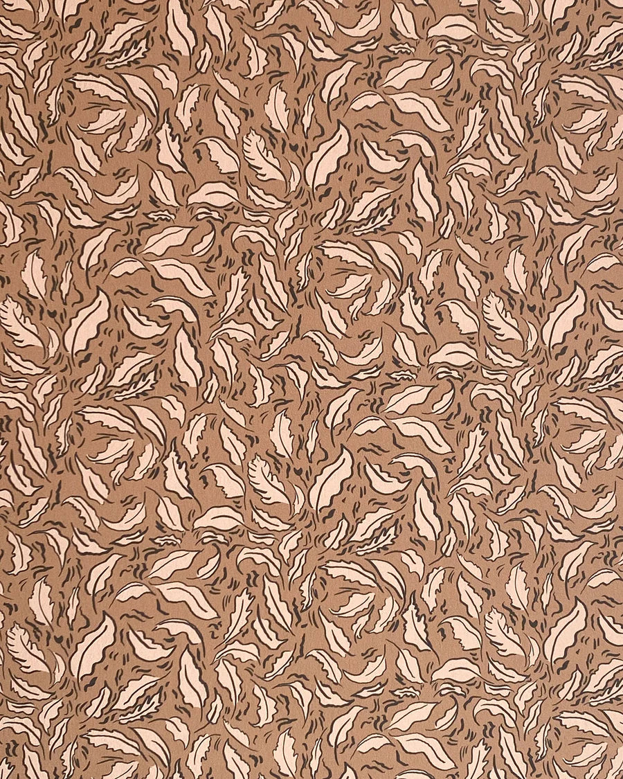 Detail of wallpaper in a painterly leaf print in cream and black on a brown field.