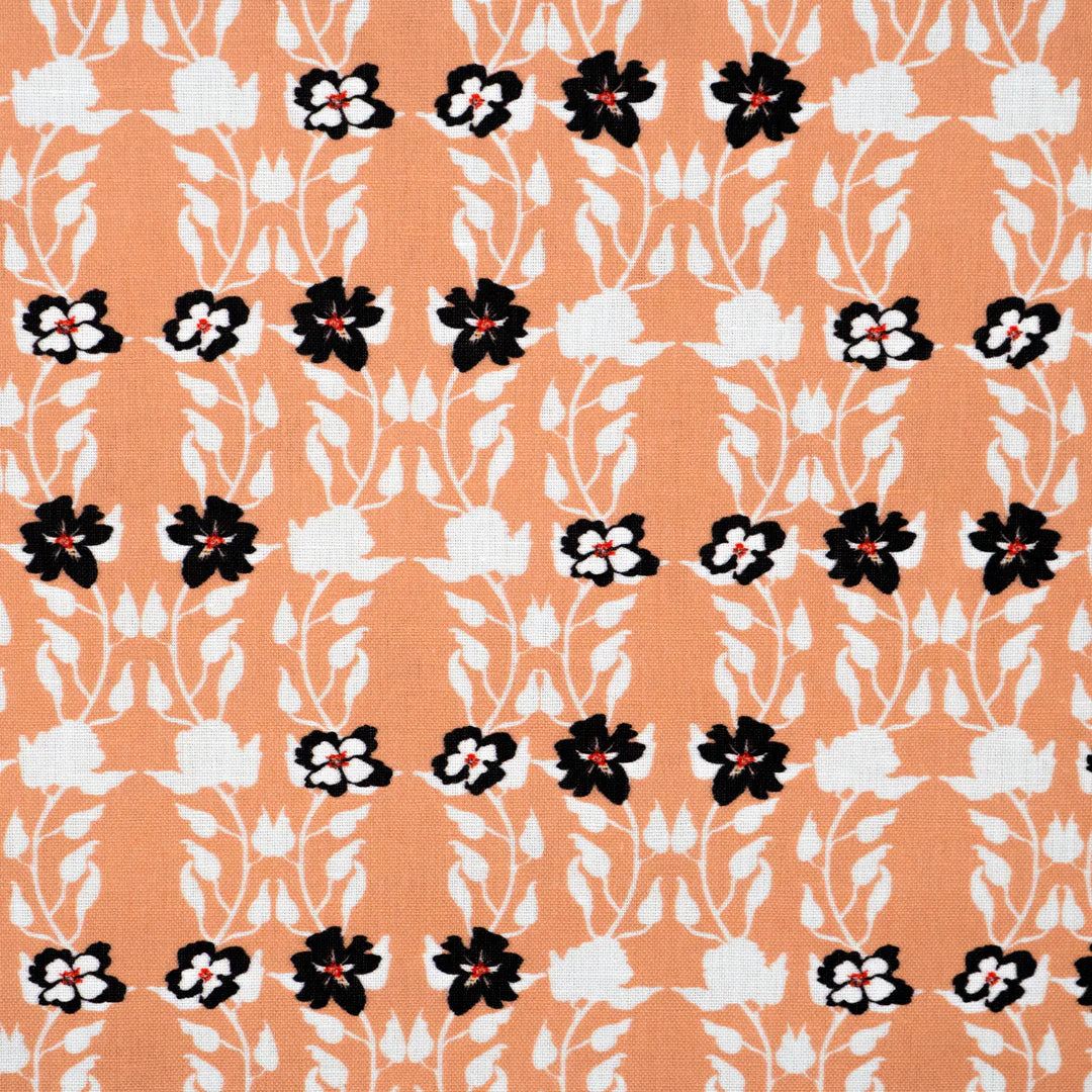 Detail of fabric in a linear floral print in red, white and black on an orange field.