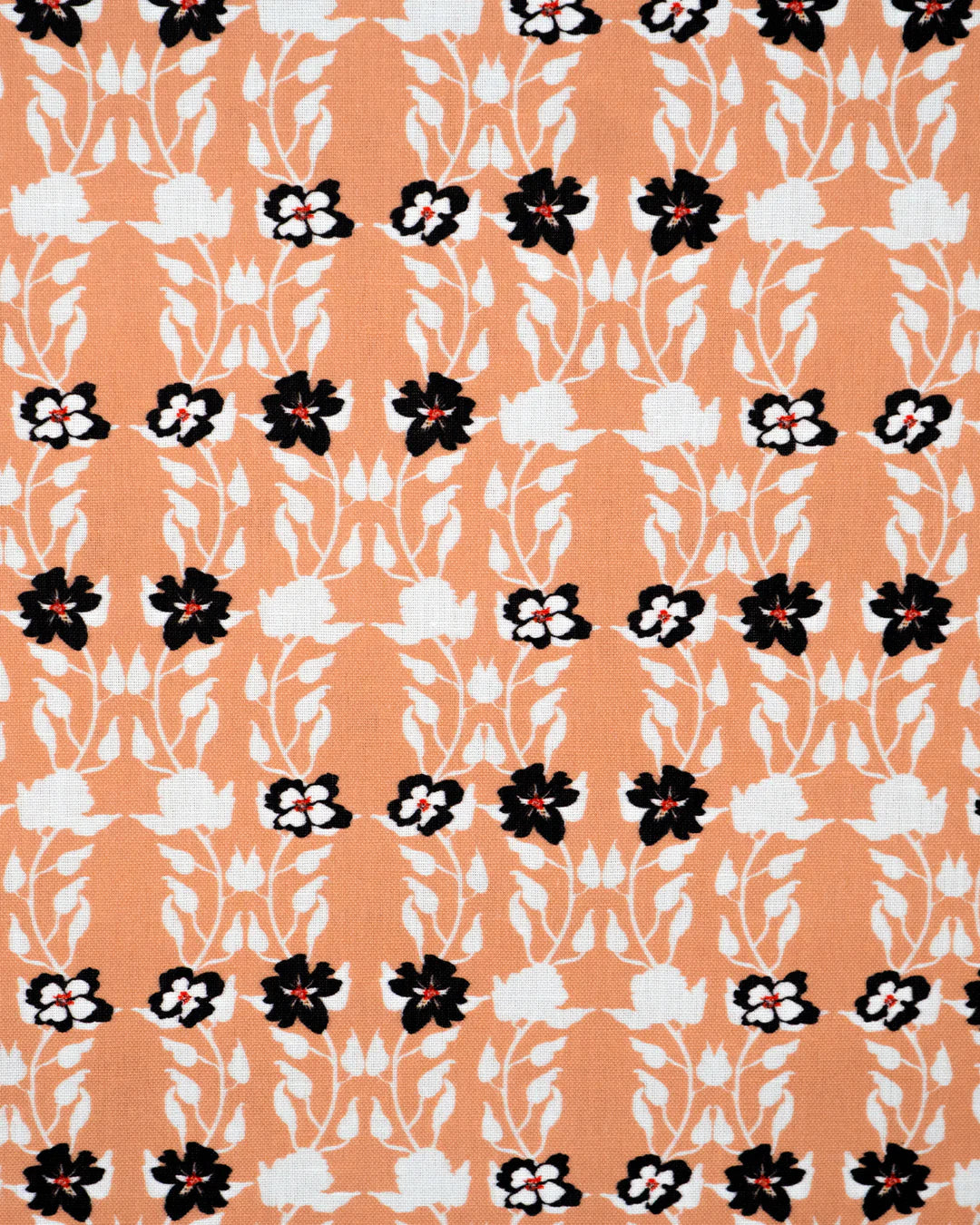 Detail of fabric in a linear floral print in red, white and black on an orange field.