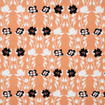 Detail of fabric in a linear floral print in red, white and black on an orange field.