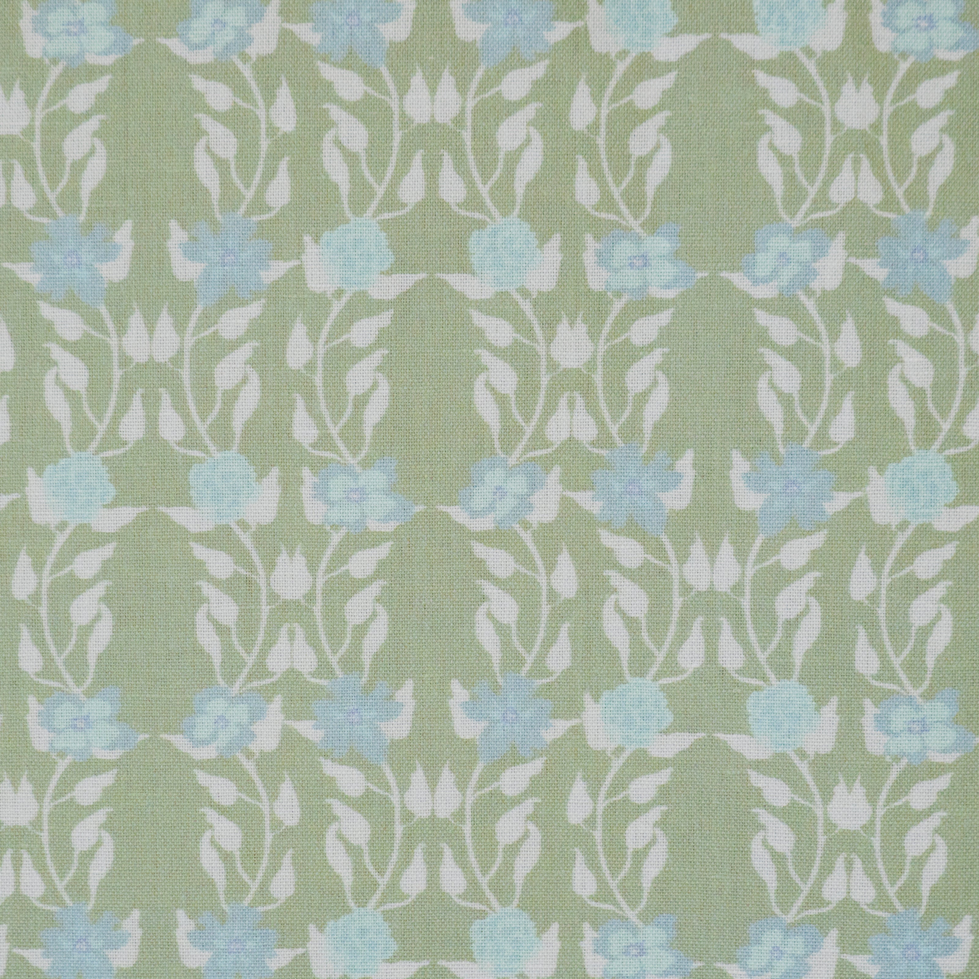 Detail of fabric in a linear floral print in blue and white on a green field.