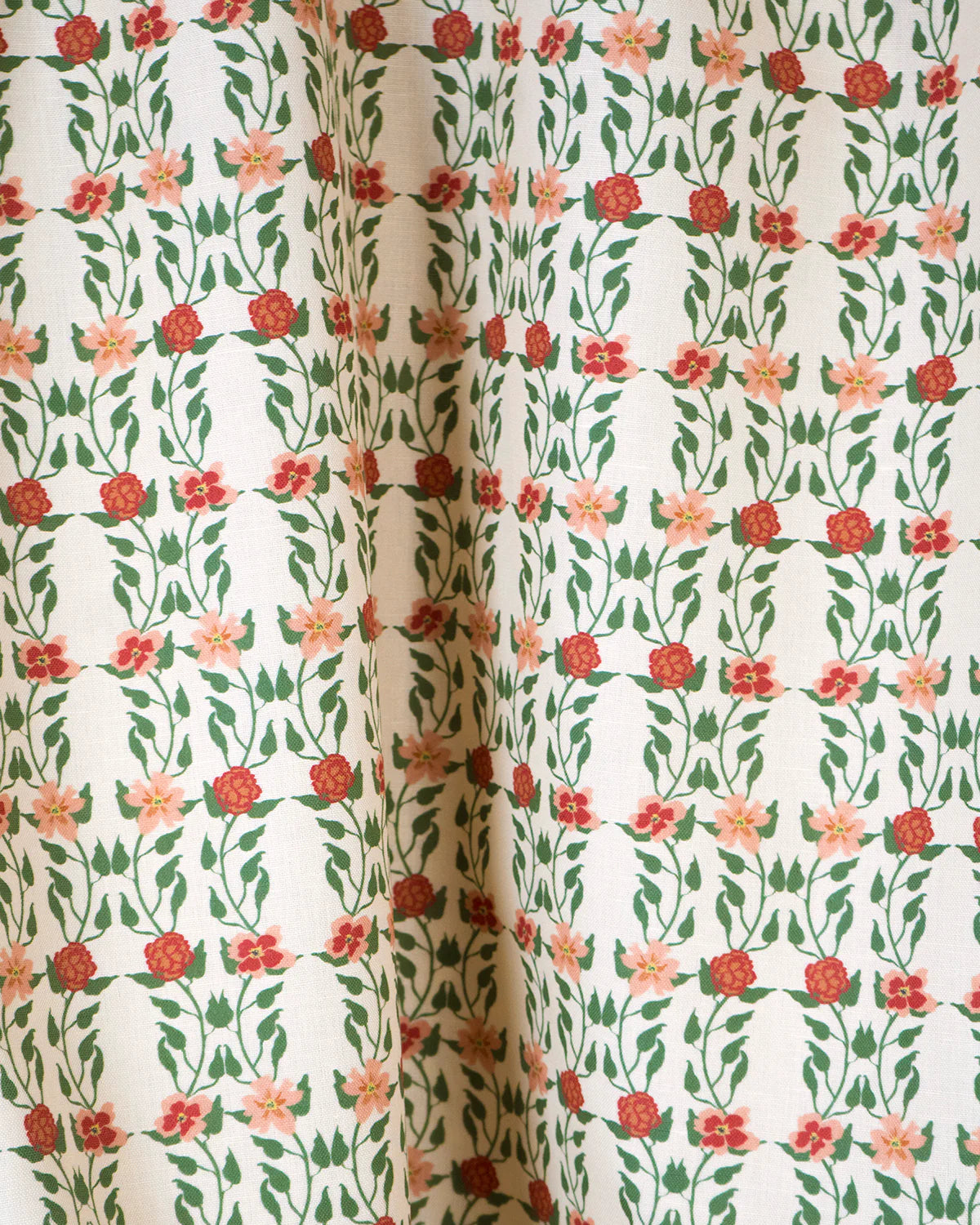 Draped fabric yardage in a linear floral print in red, orange and green on a white field.