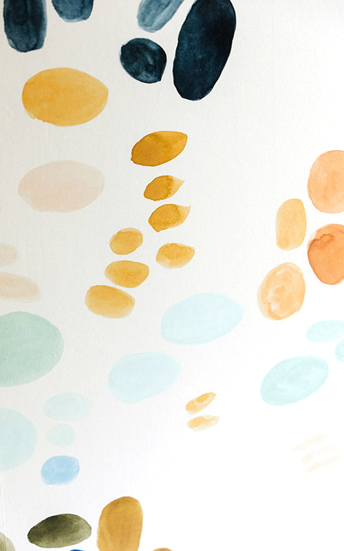 Detail of wallpaper in an abstract painterly print in shades of turquoise, blue and orange on a white field.