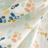 Draped fabric yardage in an abstract painterly print in shades of turquoise, blue and orange on a white field.