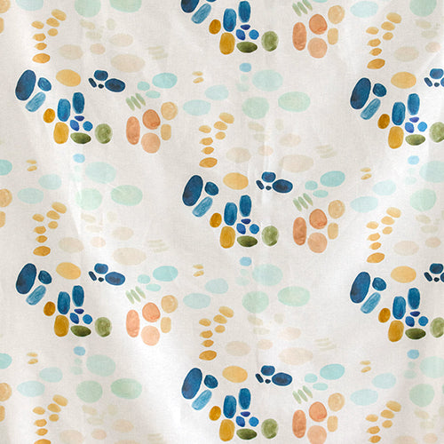 Detail of fabric in an abstract painterly print in shades of turquoise, blue and orange on a white field.