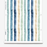 Partially unrolled wallpaper yardage in a painterly stripe print in shades of blue, green and tan on a white field.
