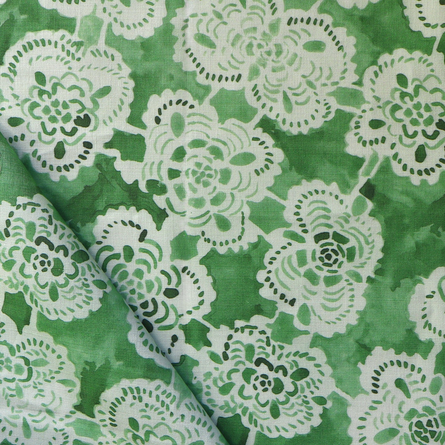Green fabric with white lace-like floral patterns