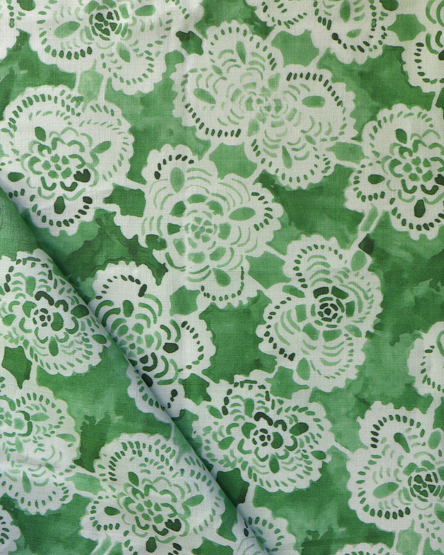 Green fabric with white lace-like floral patterns