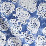 White lace-like patterns on a blue watercolor background