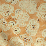 Patterned fabric with lace-like design on an yellow background