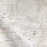 Close-up of a watercolor lace design in soft beige. 