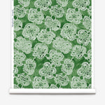 Wallpaper roll with green watercolor lace floral pattern on a white background.