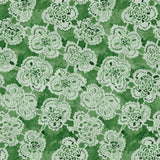 White lace floral pattern on a green background