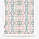 Partially unrolled wallpaper yardage in a painterly gometric stripe in gray, blue and green on a pink field.
