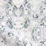 Detail of fabric in an abstract paint blotch print in gray and turquoise on a white field.