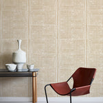 Modern brown chair and small table against a beige wallpapered wall.