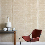 Modern brown chair and small table against a beige wallpapered wall.