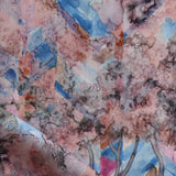 Detail of fabric in a painterly botanical print in pink, orange, gray and blue.