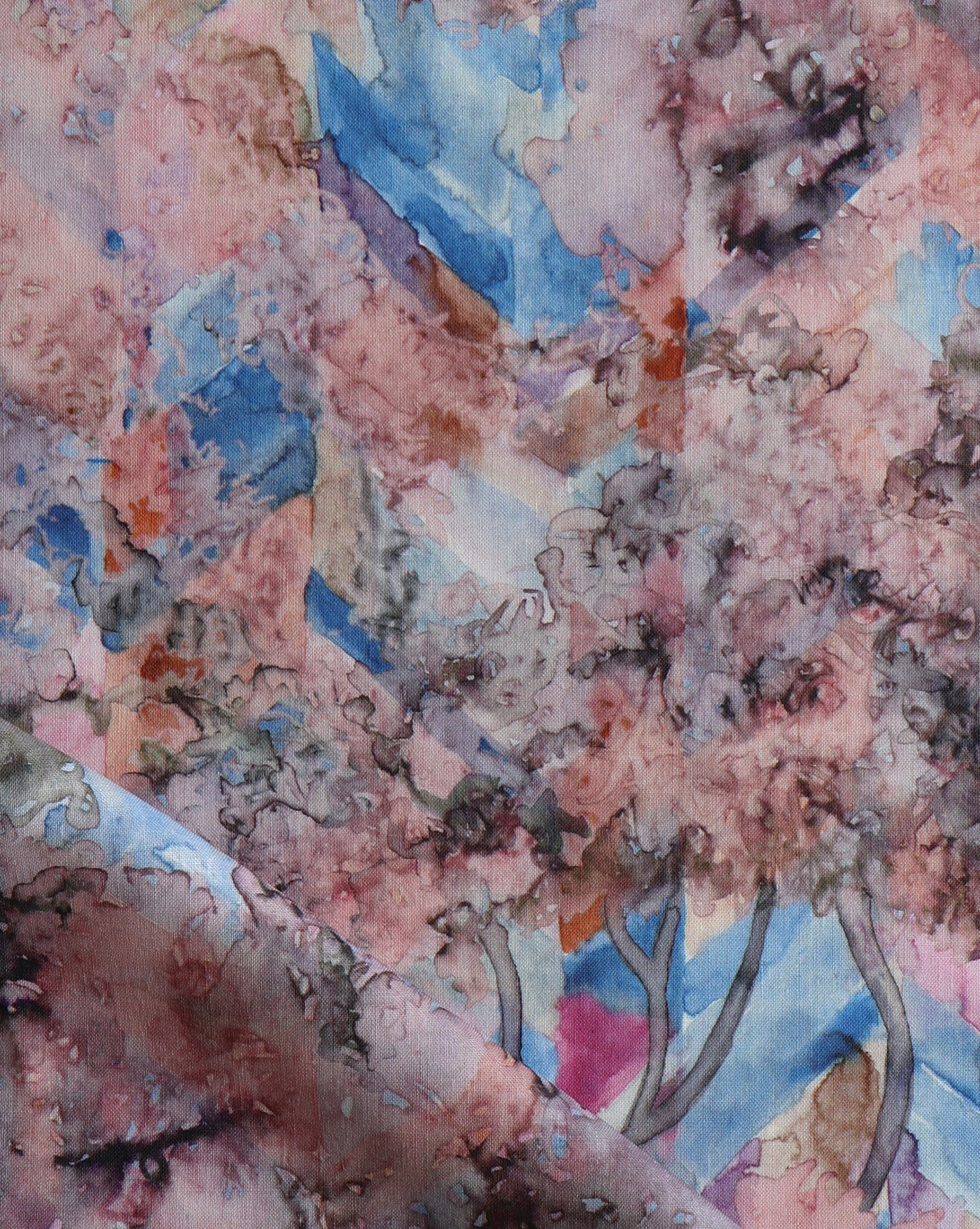 Detail of fabric in a painterly botanical print in pink, orange, gray and blue.