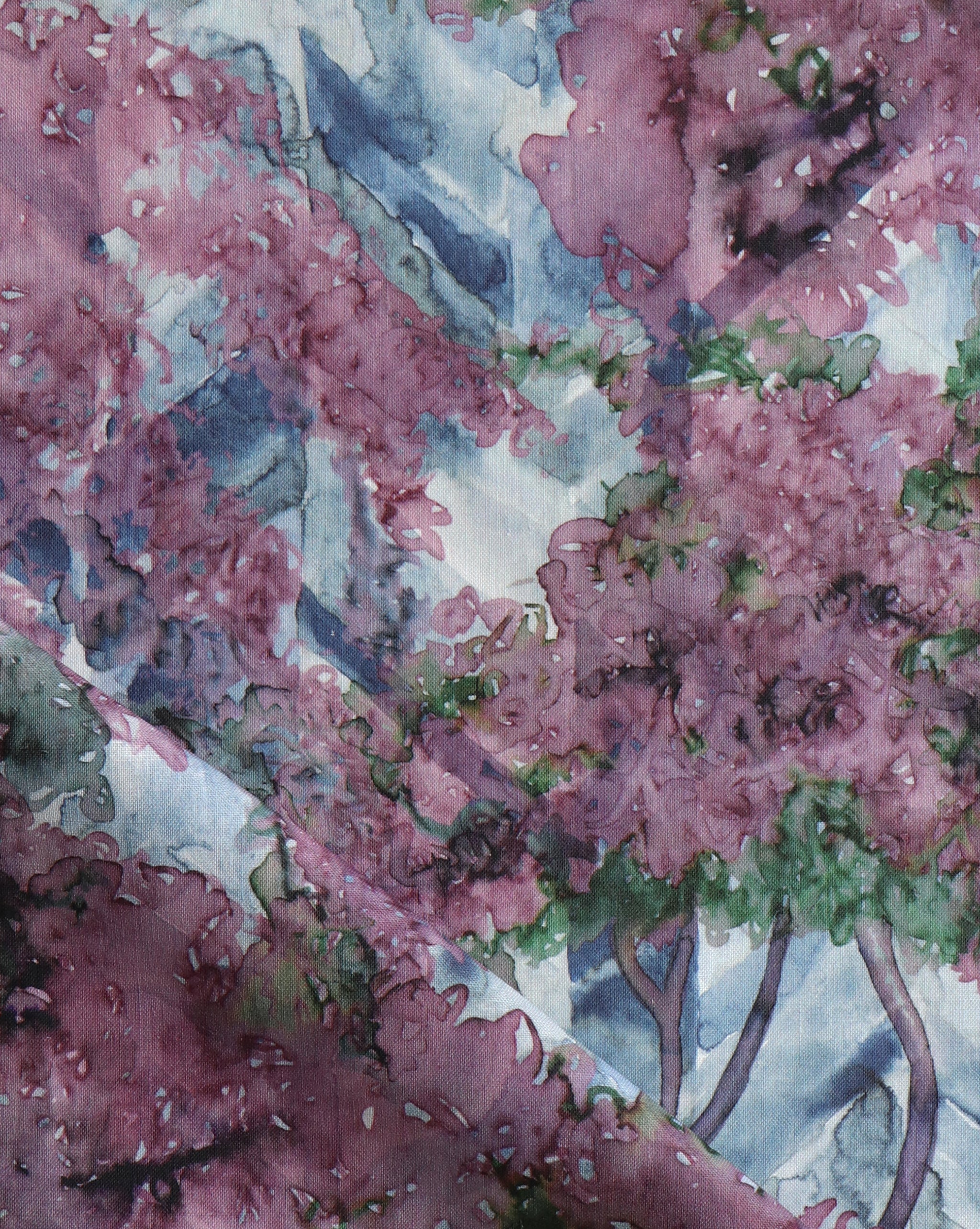 Detail of fabric in a painterly botanical print in purple, green and brown.