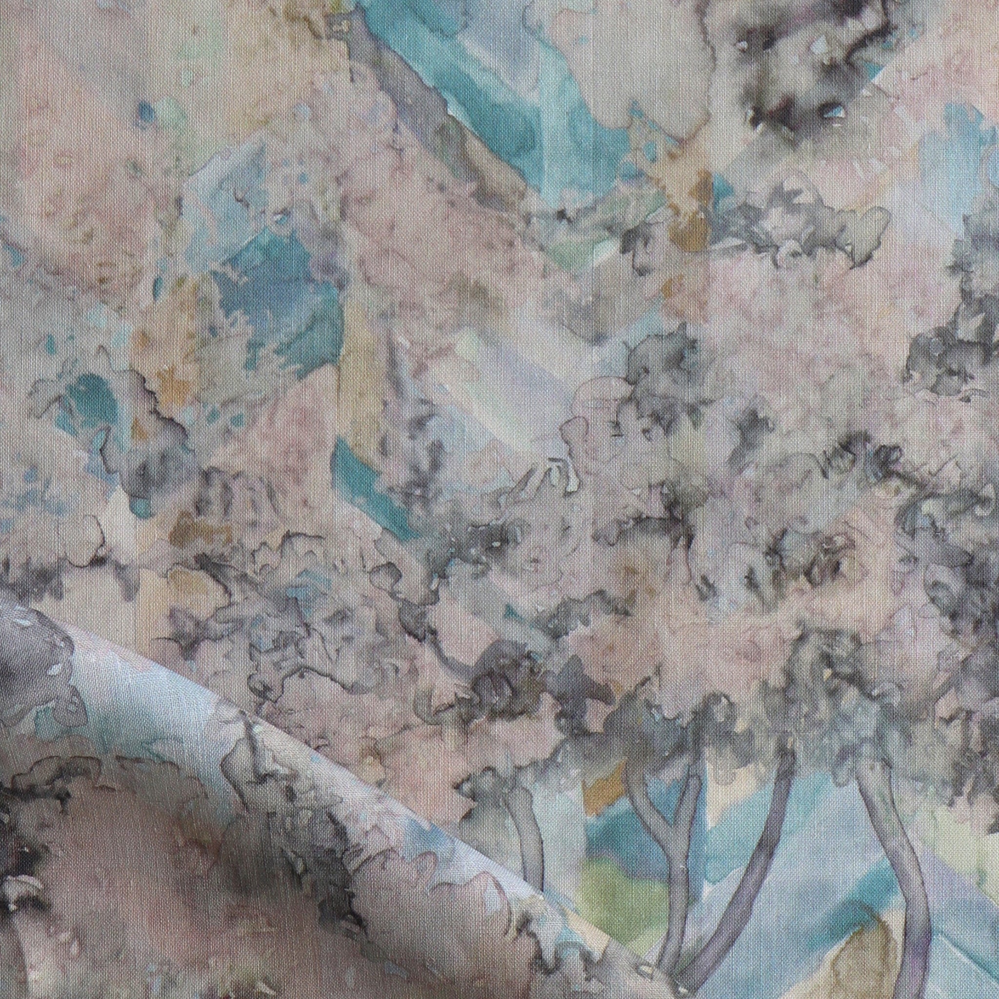 Detail of fabric in a painterly botanical print in cream, gray and turquoise.