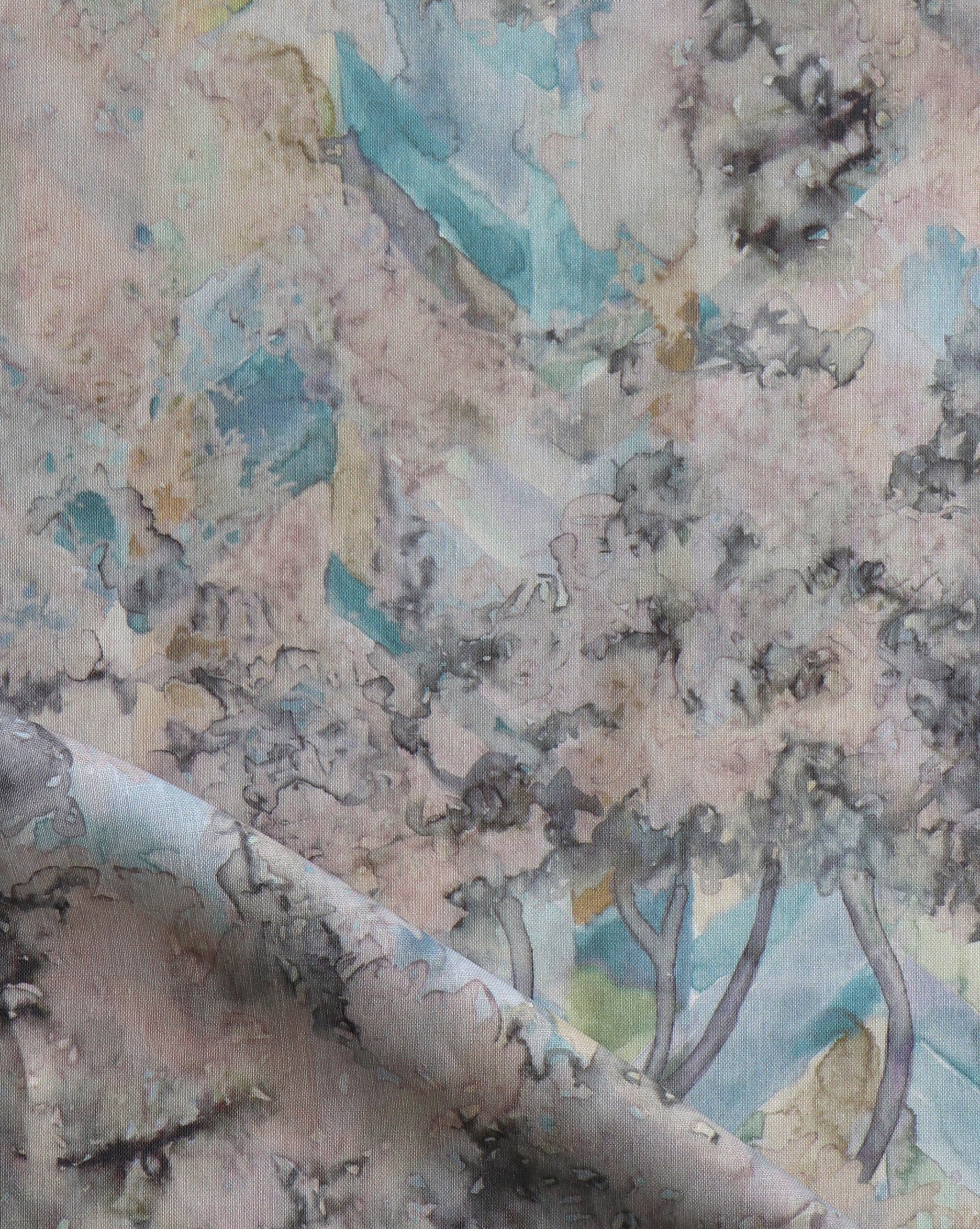 Detail of fabric in a painterly botanical print in cream, gray and turquoise.