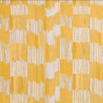 Detail of fabric in an abstract check print in shades of yellow and white.