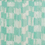 Detail of fabric in an abstract check print in shades of turquoise and cream.