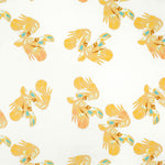 Detail of fabric in a playful feather print in yellow, orange and blue on a cream field.