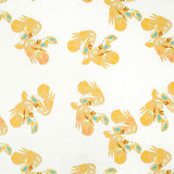 Detail of fabric in a playful feather print in yellow, orange and blue on a cream field.