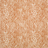 Detail of fabric in a playful animal print in burnt orange on a white field.