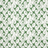 Detail of fabric in a playful abstract shape print in white on a green field.