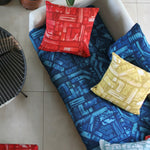 An overhead shot of a sofa topped with throw pillows, all upholstered in different colorways of the same geometric print.