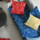 An overhead shot of a sofa topped with throw pillows, all upholstered in different colorways of the same geometric print.