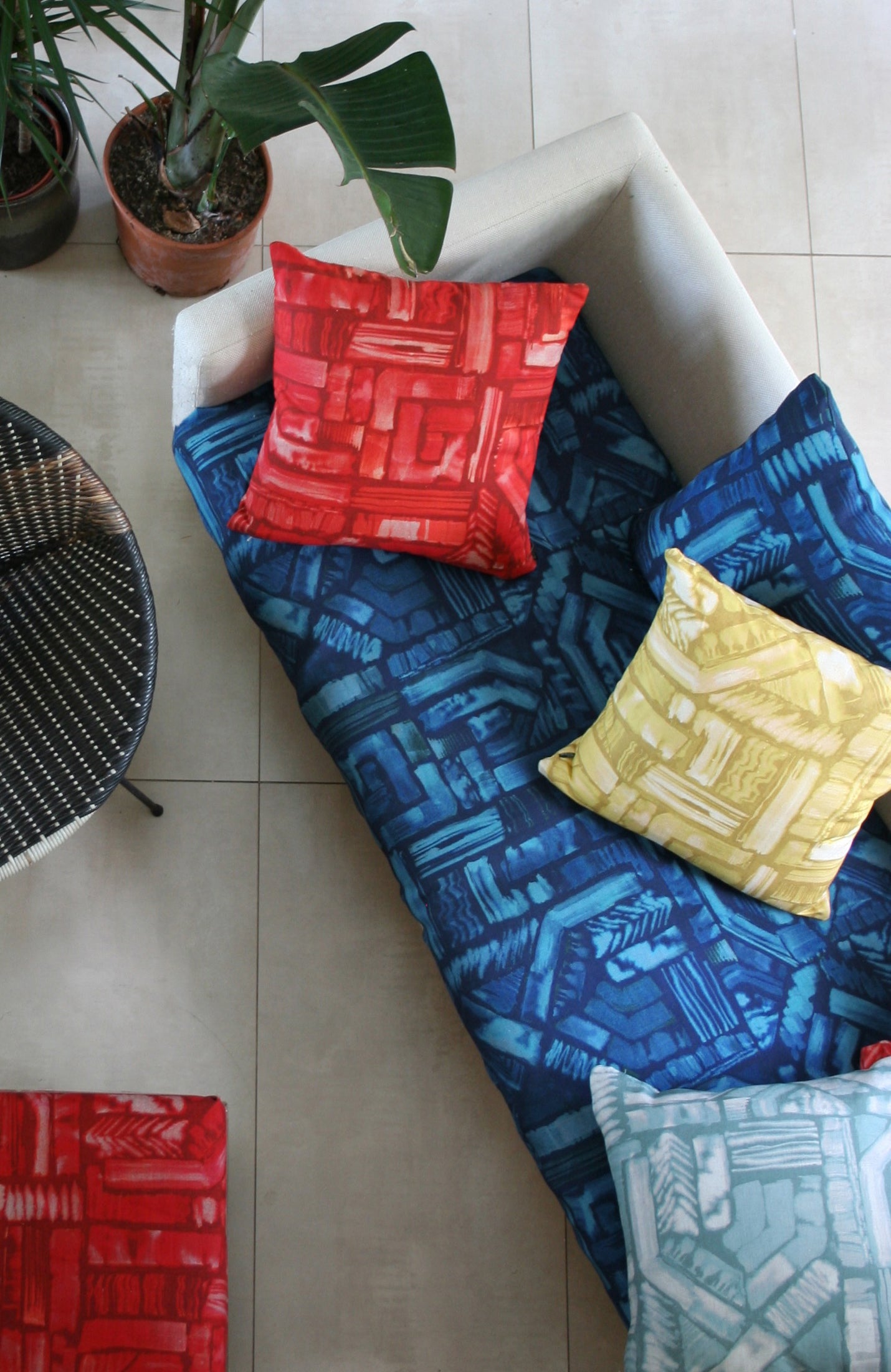 An overhead shot of a sofa topped with throw pillows, all upholstered in different colorways of the same geometric print.